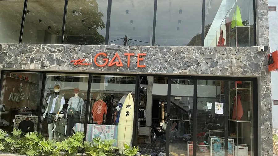 Mặt tiền The Gate Tam Cốc: tường đá, biển the GATE, mặt kính và cây xanh trước cửa